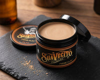Suavecito Clay Pomade - open pot met beige clay-textuur op leisteen