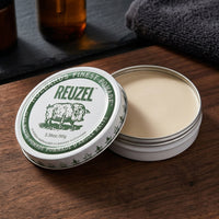 Reuzel Clay Matte Pomade - open blik met zichtbare textuur, deksel op houten plank