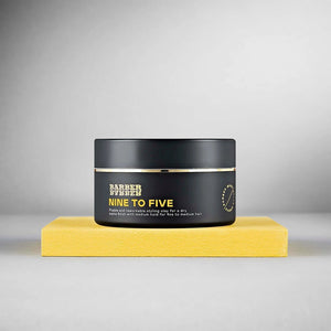 BARBER BARBER Nine To Five Medium Hold Styling Clay 100g - sort krukke på gul blok, gråt studie