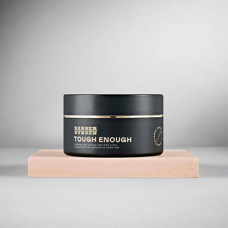 BARBER BARBER Tough Enough Strong Hold Styling Clay 100g - zwart potje op beige blok, grijze studio