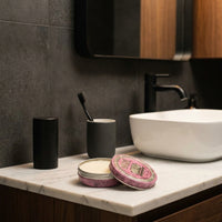 Reuzel Pink Pomade Grease - blik op marmeren wastafel in donkere badkamer