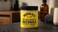 Murrays Beeswax - geel potje op donkere leisteen in barbershop