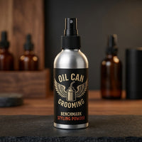 Oil Can Grooming Benchmark Styling Powder - spuitfles vooraanzicht tussen bruine flesjes