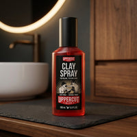 Uppercut Clay Spray - flacon op leisteen bij ronde verlichte spiegel